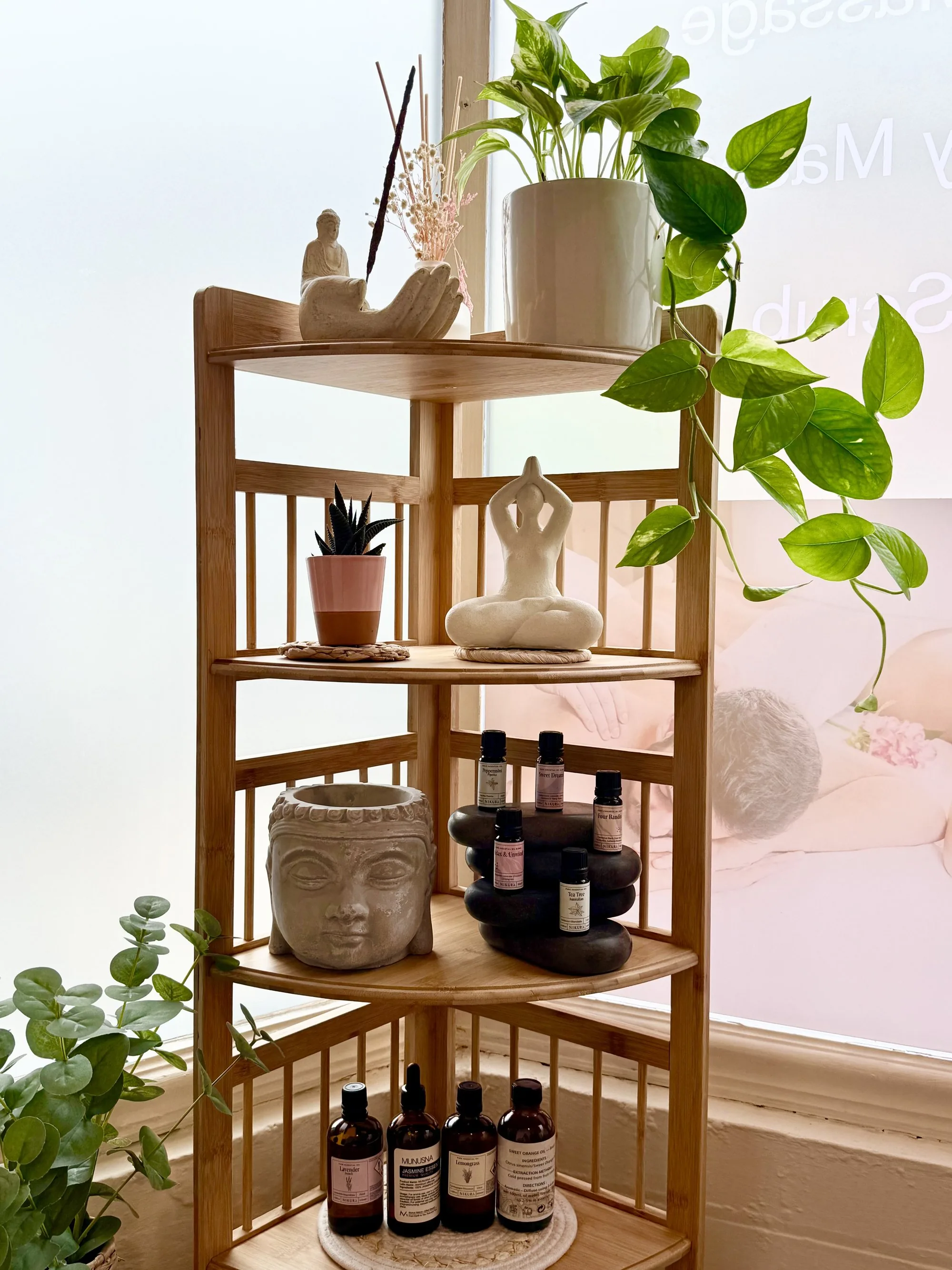 Bamboo shelf with green plants, Buddha planter and massage oils at Thai Lanna Treatment, Coventry